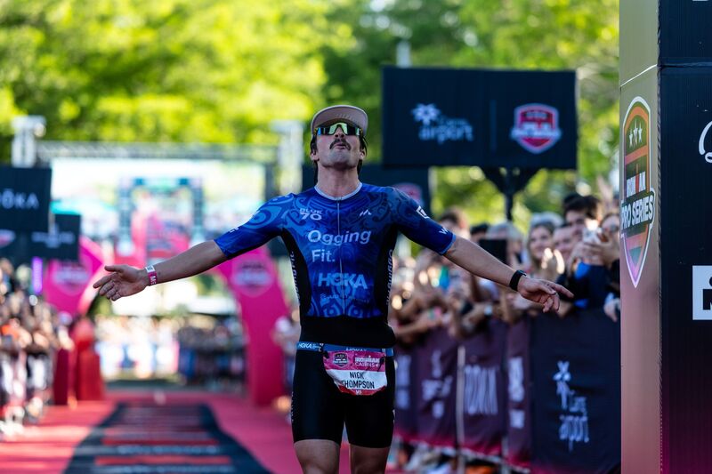 Nick Thompson crossing the Ironman Cairns finish line with his arms out